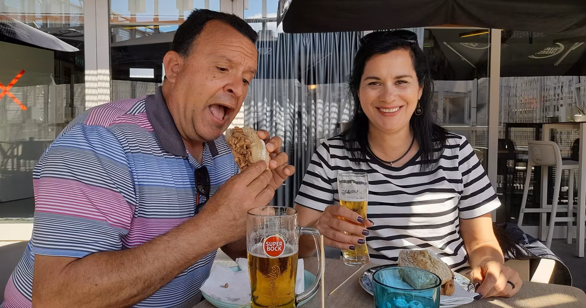 Couple tasting Portuguese bifana and Super Bock on a Braga food tour, 3-hour small-group lunch