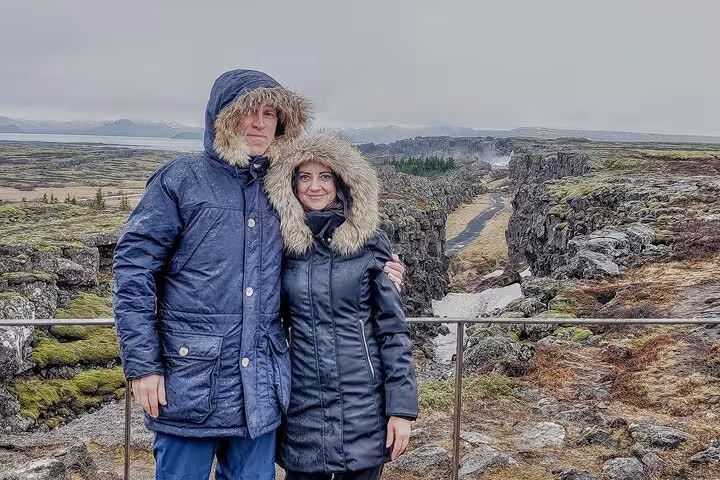 Couple in winter jackets at Þingvellir rift valley on Golden Circle tour, Iceland