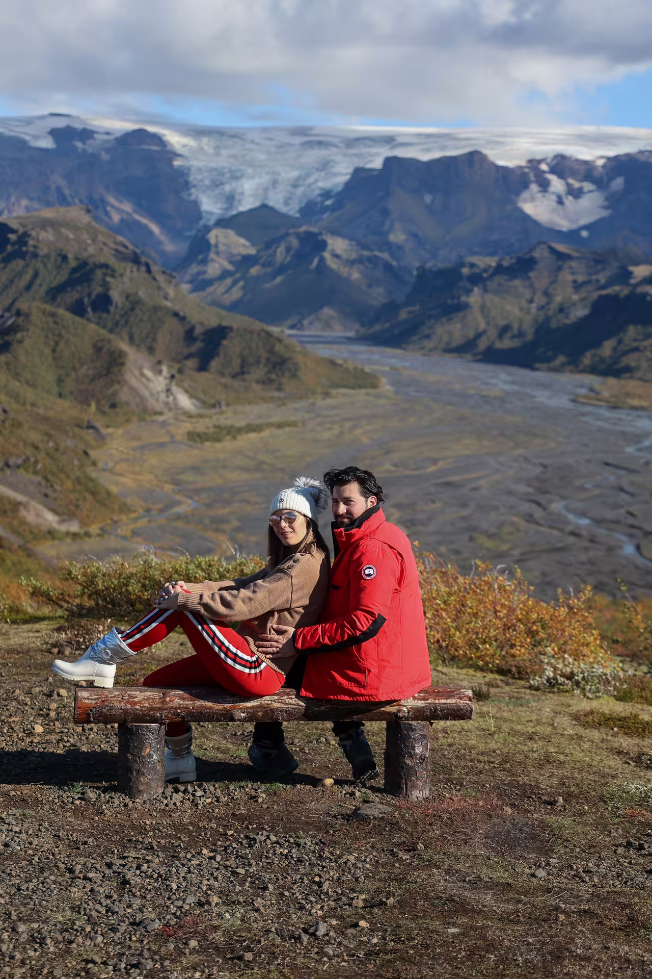 Couple sitting on scenic Thorsmork overlook bench with glacier river valley backdrop on Iceland full-day 4x4 tour