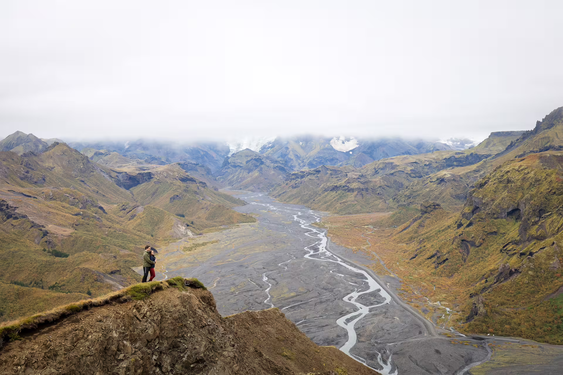 Couple standing on a cliff overlooking the breathtaking Thorsmork valley landscape on an Iceland 4x4 tour