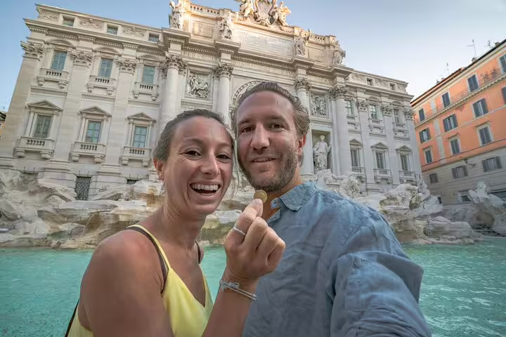 Couple holding coin in front of Trevi Fountain in Rome