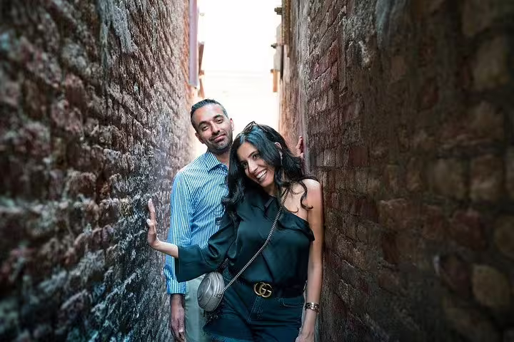 Couple posing in a narrow Venetian alley during a private photo shoot in Venice with gondola ride.