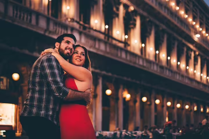 Couple hugging under evening lights in Venice, captured on a private tour with personal travel photographer