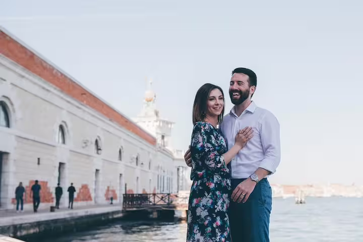 Couple posing on Venice waterfront promenade during a private tour with personal travel photographer