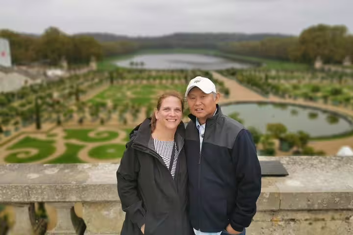 Couple overlooking Versailles Gardens and Grand Canal during a full-day private guided tour with hotel pickup