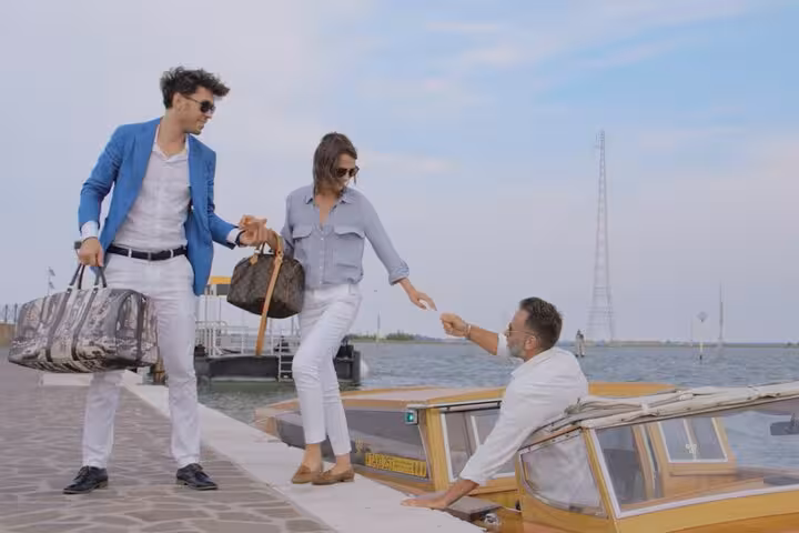 Couple with luggage boarding a water taxi from Venice Airport for transfer to Mestre, highlighting convenient travel.