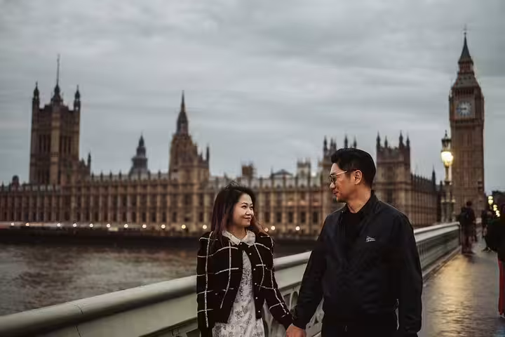 Couple walking hand in hand on Westminster Bridge with Big Ben in the background during a private London tour.
