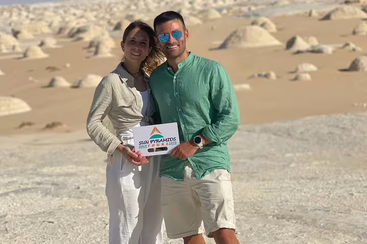 Couple holding tour sign in Egypt White Desert, Bahariya Oasis 3 days 2 nights desert safari package
