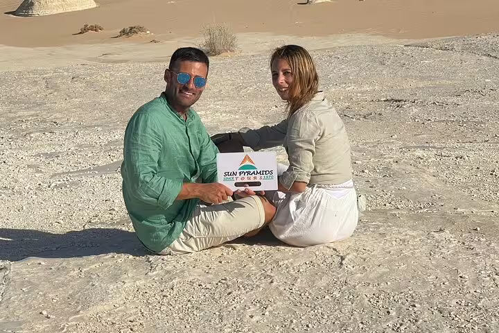 Couple sitting on chalky sand in Egypt’s White Desert during a private 2-day Jeep safari to Bahariya Oasis