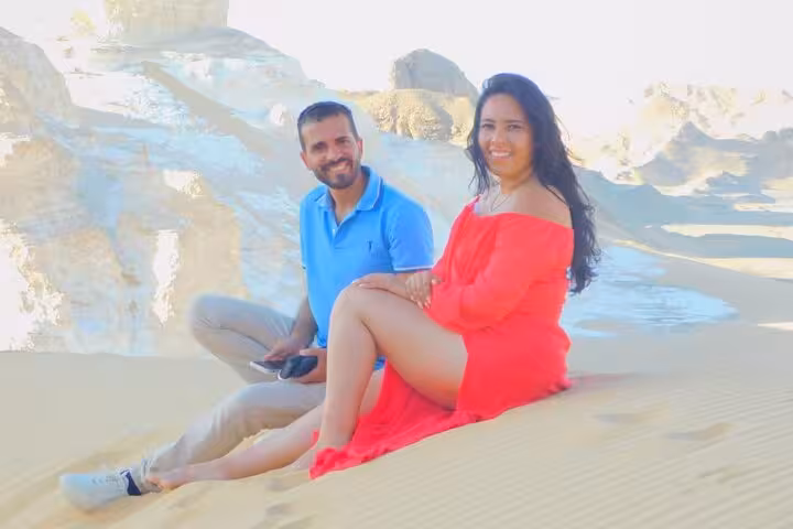 Couple sitting on sand dunes in Egypt’s White Desert, scenic photo stop on 3-day desert camping trip