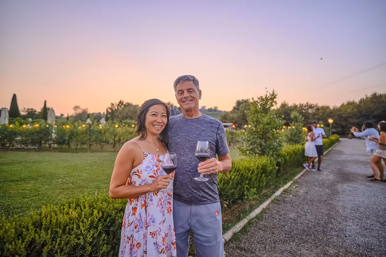 Couple enjoying wine at sunset in Chianti vineyard during a small-group winery tour experience.
