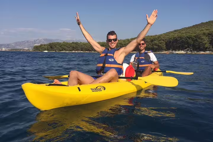 Happy couple in yellow sea kayak on Adriatic near Split, Croatia, on guided kayaking and snorkeling tour