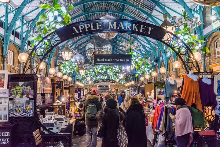 Bustling Covent Garden's Apple Market during a private London city tour, showcasing vibrant stalls and handmade arts.