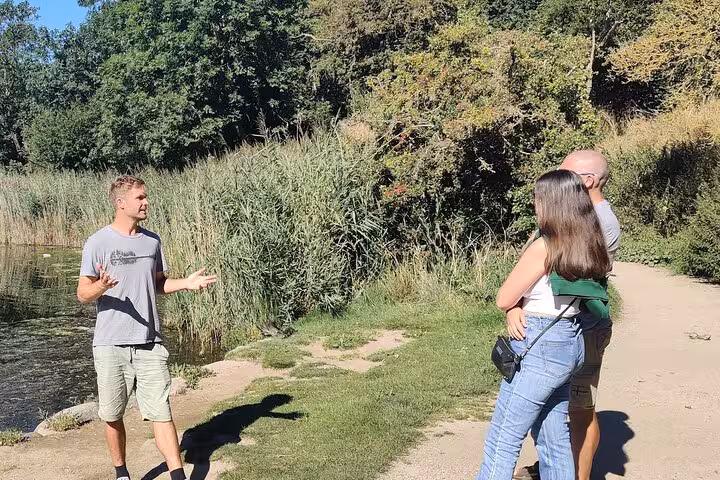 Visitors engage with guide on a nature path during a small group walking tour with coffee and culture.