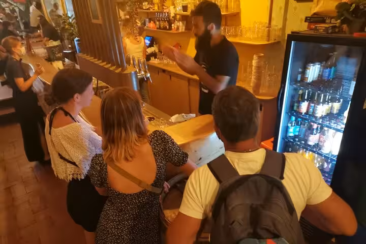 Small group craft beer tasting in Marseille as the bartender explains brews at a local taproom bar