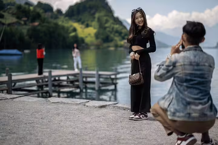 Tourists capture memorable moments by Lake Brienz during the Crash Landing on You tour in scenic Interlaken, Switzerland.