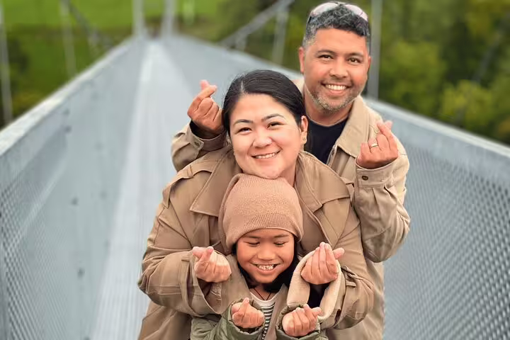 Family enjoying the scenic pedestrian suspension bridge on the Crash Landing on You tour in Switzerland.
