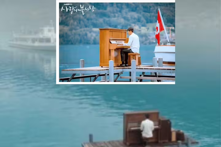 Scene from Crash Landing on You with a pianist on a dock by Lake Brienz, Switzerland, highlighting picturesque landscapes.