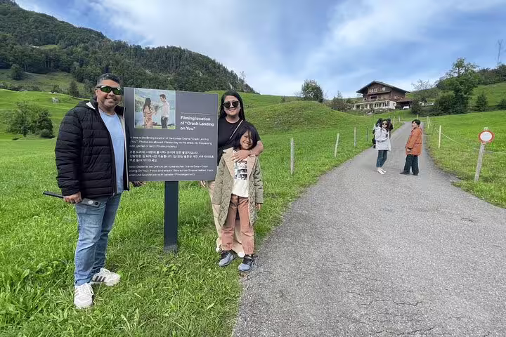 Tourists pose by a filming location sign for Crash Landing on You, set amidst scenic Swiss landscapes on the private tour.