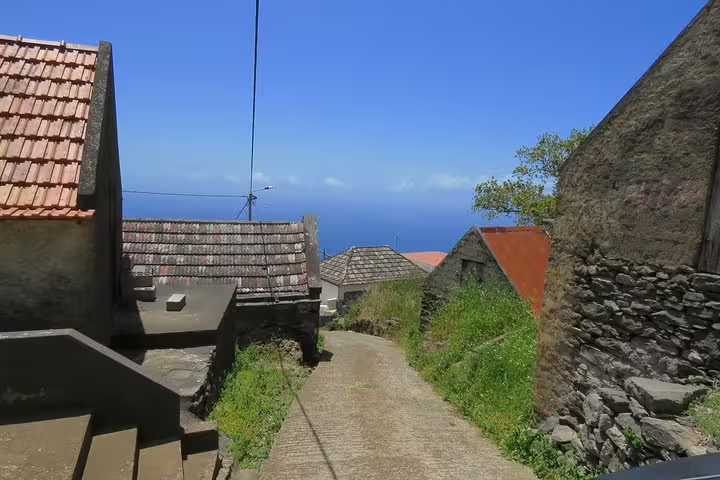 Scenic hillside village path with ocean view, perfect for exploring on the Craters of Fire 4X4 Full-Day Tour adventure.
