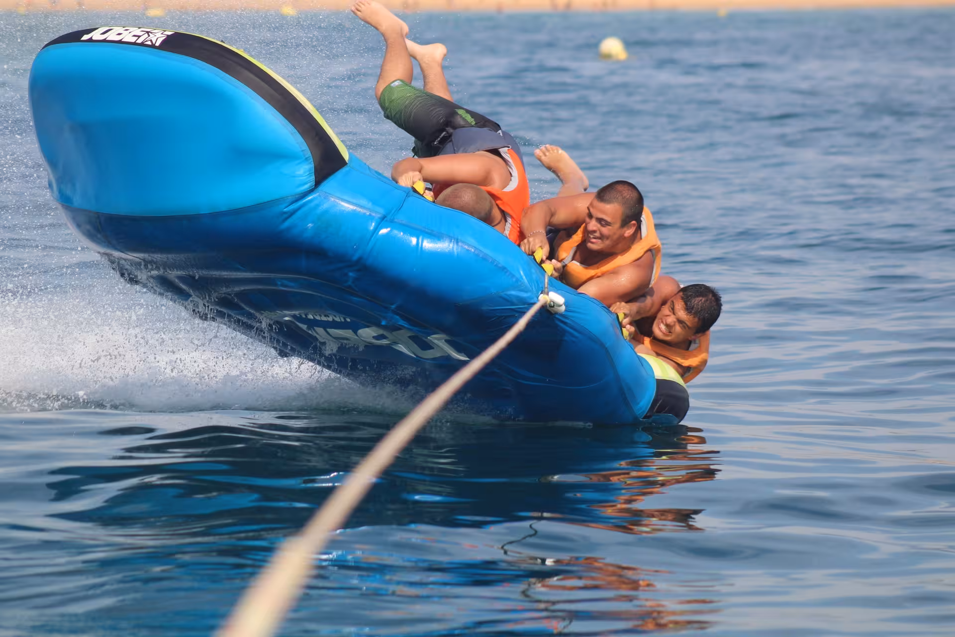 Thrilling Crazy Cookie water tube ride flipping sideways as laughing riders hold on during an exciting ocean adventure