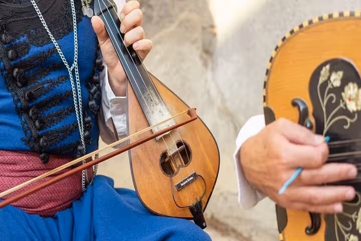 Close-up of Cretan lyra and laouto musicians performing live at a Cretan Night with food and folk dancing