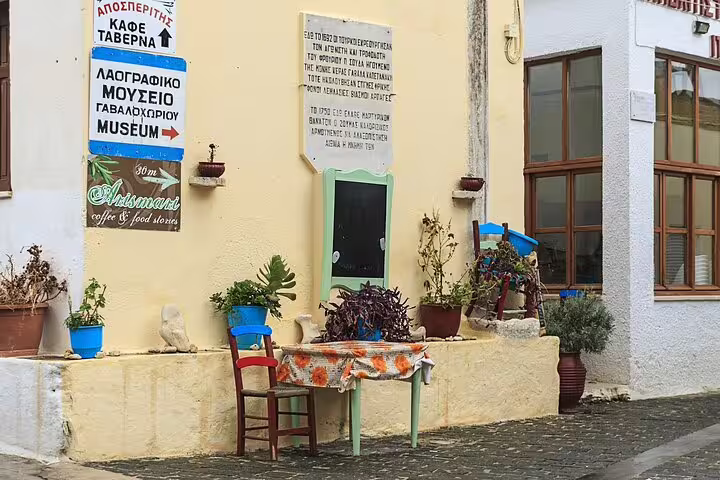Charming Cretan village scene with colorful chairs and plants outside a traditional taverna in Apokoronas.