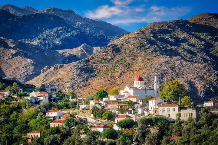 Charming Cretan village with traditional white houses and a red-domed church nestled in the scenic Apokoronas mountains.