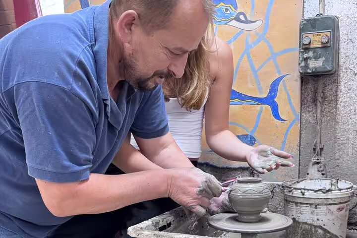 Pottery lesson in Crete, visitors crafting traditional ceramics during interactive tour.