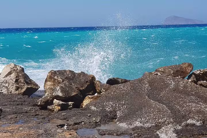 Waves crashing against rocks on the stunning South Coast of Crete with turquoise sea views.
