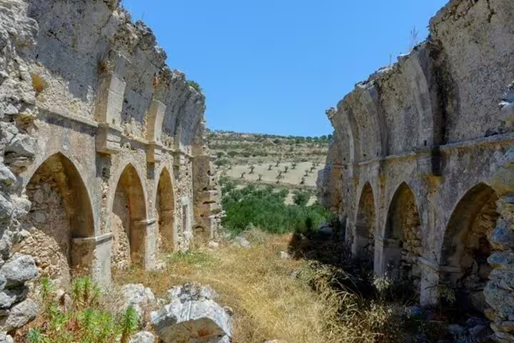 Ancient stone arches with scenic olive groves in Crete, perfect for the Heraklion Villages and Vines wine tasting tour.
