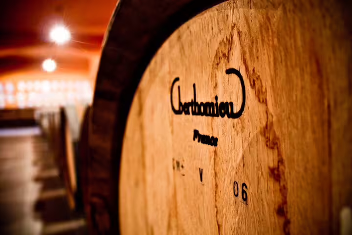 Wooden wine barrel in a dimly lit Crete cellar, highlighting traditional wine-making techniques and culture.