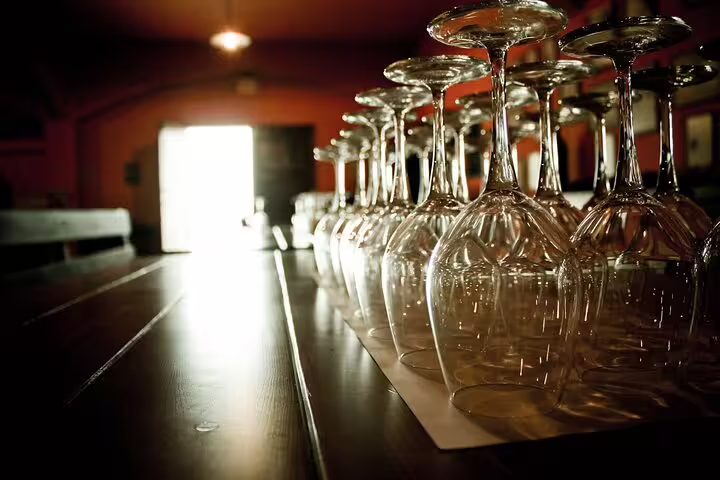 Sunlit arrangement of wine glasses on a wooden table, ready for a tasting session on the Crete Wine Discovery Tour.