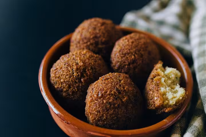 Crispy Egyptian falafel served in a rustic bowl, showcasing traditional flavors on a Cairo food tour.