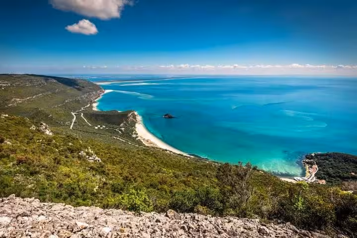 Stunning panoramic view of Arrábida's lush green hills and turquoise coastline, ideal for private tours in Portugal.