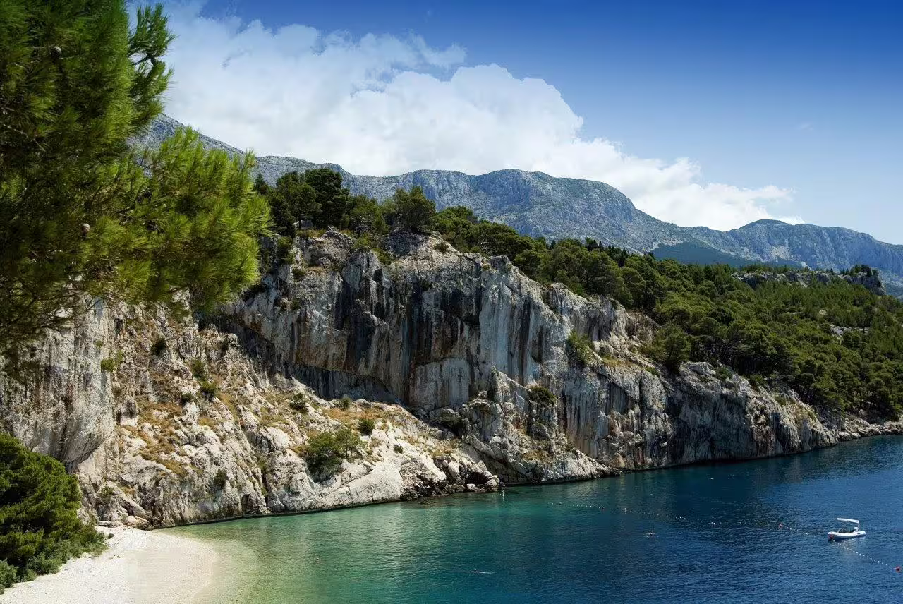 Rocky Adriatic cove with turquoise water and pine cliffs, scenic coastal drive on Croatia 11-day self-drive
