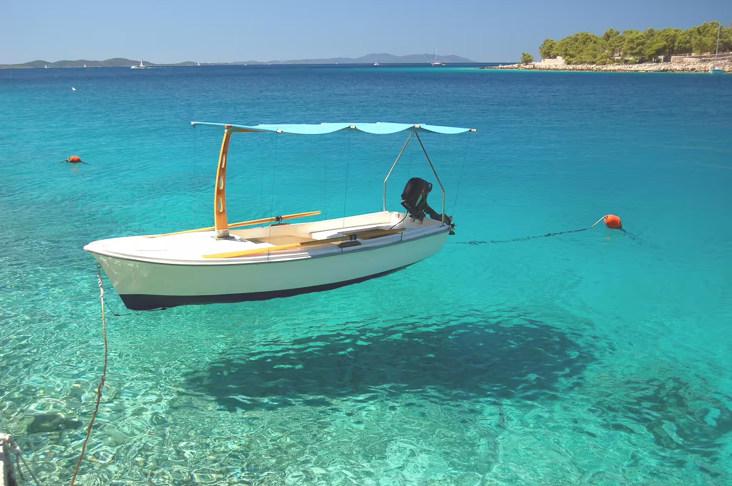 Small motorboat floating in crystal-clear Adriatic water on Croatia island hopping 11-day cruise itinerary