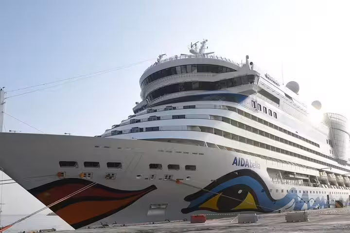 Majestic cruise ship docked in Muscat harbor, showcasing vibrant hull design and luxury amenities for travelers.