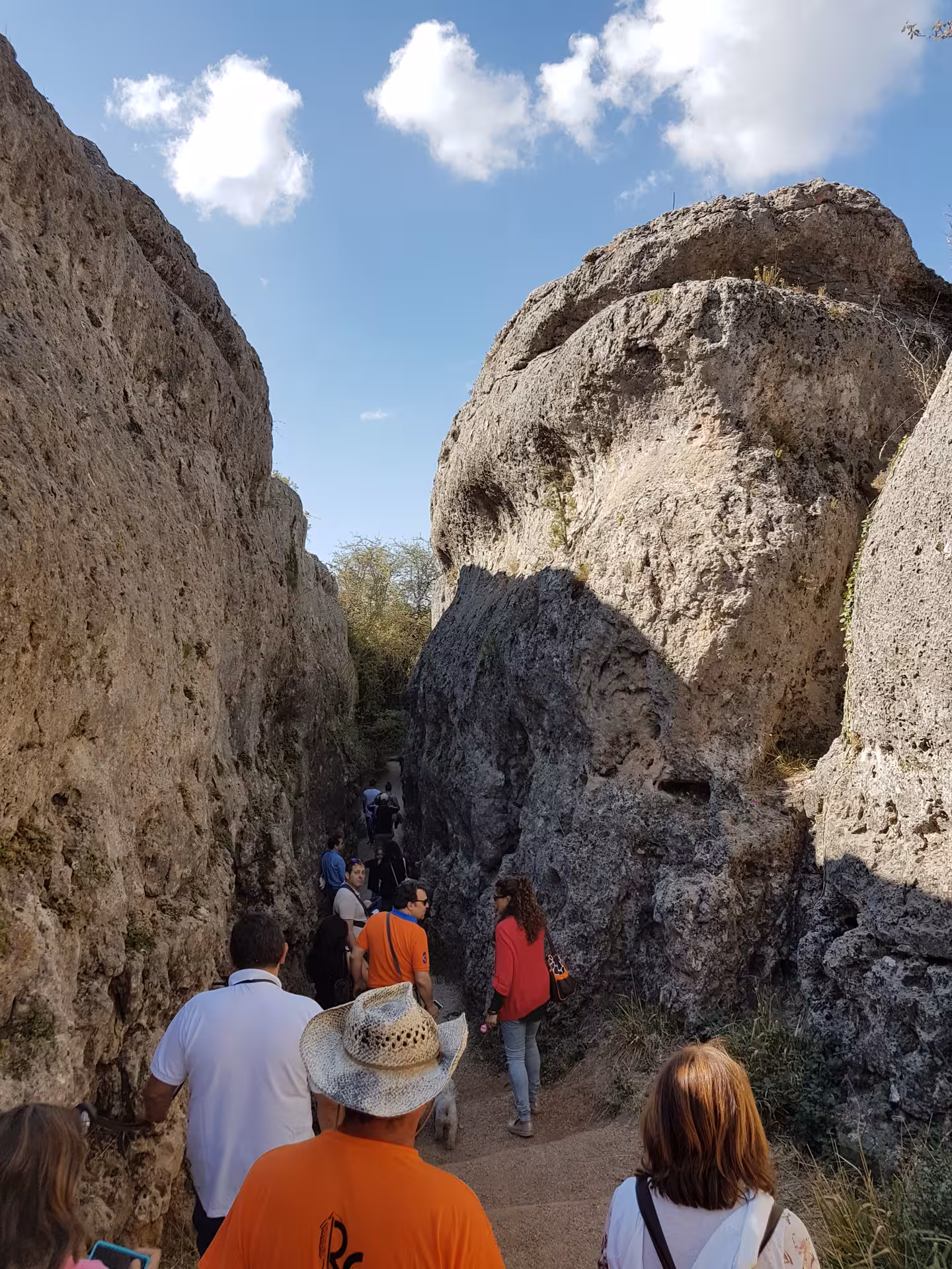 Hikers walk between towering limestone walls in Ciudad Encantada on a Cuenca day tour from Madrid