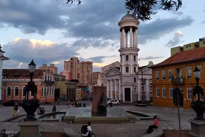Historic square with colonial architecture and fountain in Curitiba city center during shared tour.