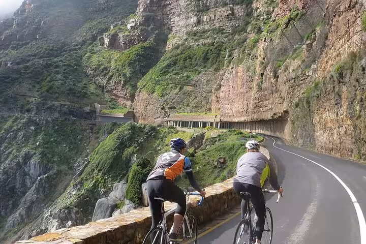 Cyclists enjoy scenic ride along Chapman's Peak Drive on Cape Point tour from Cape Town.