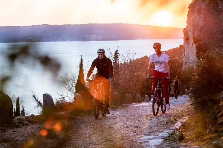 Cyclists riding coastal trail at sunset in Split, a scenic bike ride on the Bike, Beer & Poljud Stadium Tour