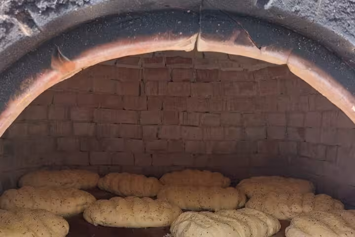 Traditional Cypriot village oven baking sesame bread during authentic cultural food workshop and wine tour