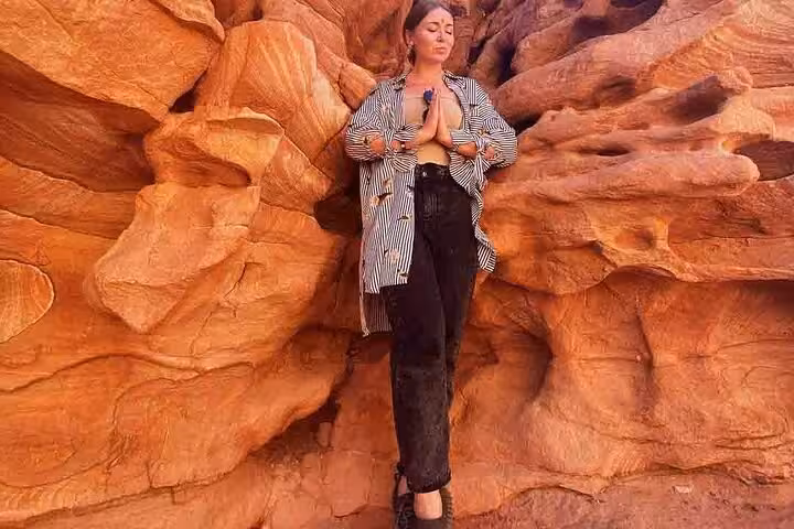 Traveler poses among Canyon Salama red sandstone cliffs on Dahab safari tour from Sharm El Sheikh, Sinai desert