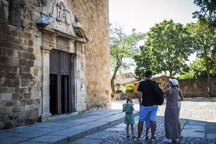 Family explores historic stone architecture at Dalí Museum entrance on Costa Brava tour.