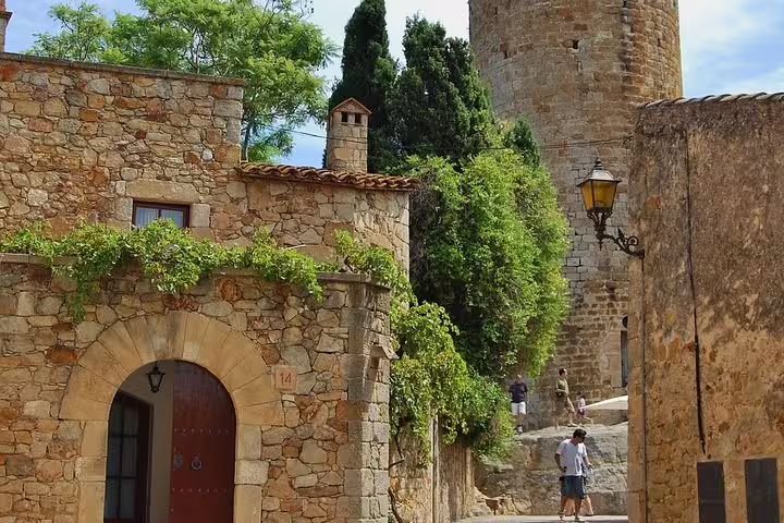 Charming medieval village in Costa Brava with stone architecture and historic tower, ideal for Dalí Museum tour exploration.