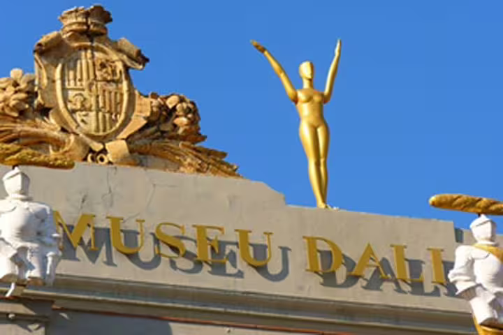 Close-up of the Dalí Museum entrance, showcasing iconic sculptures and architecture under a clear blue sky.