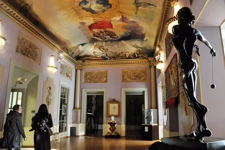 Visitors admire the ornate ceiling and sculptures inside the immersive Museum Dalí Tour.