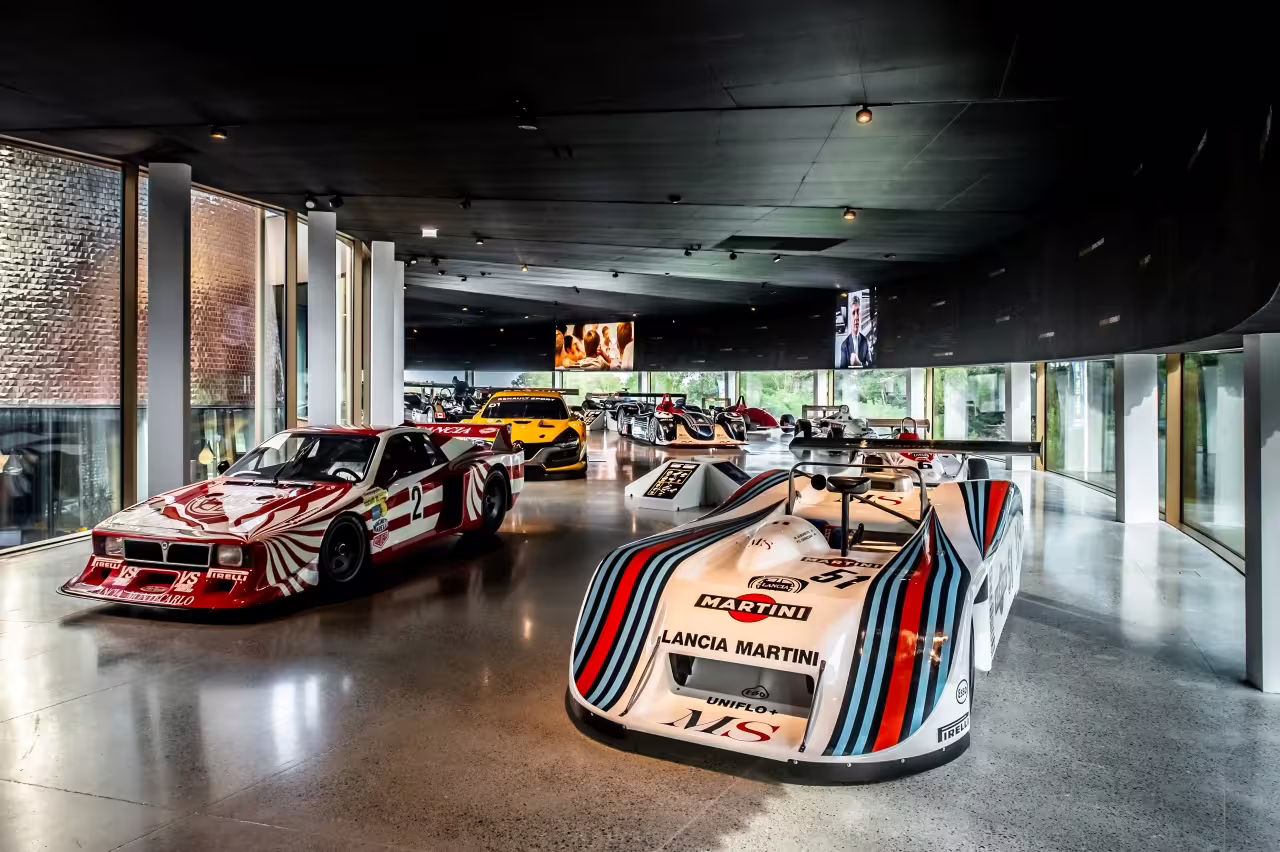Interior view of Dallara Academy showcasing iconic race cars, illustrating Parma's rich motorsport heritage.