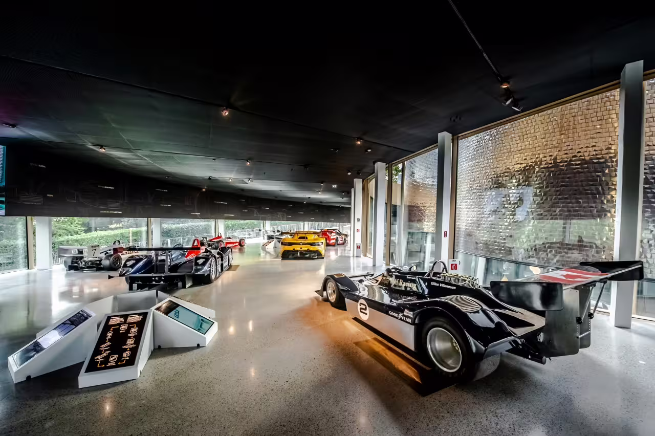 Explore iconic race cars in the sleek, modern gallery of Dallara Academy, showcasing motorsport excellence in Parma.